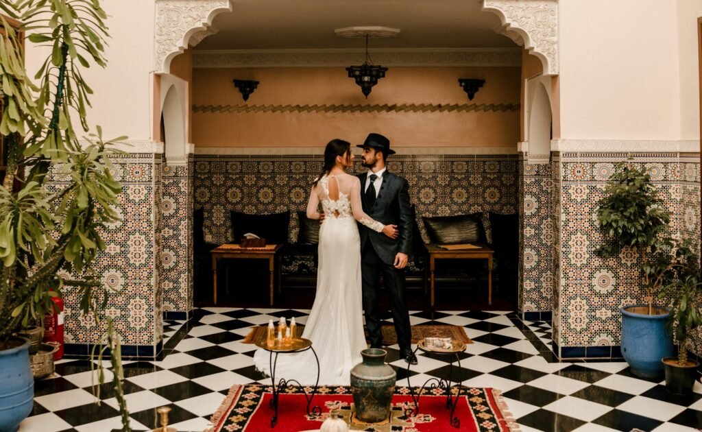 A couple dressed as brides in the interior of a Riad.